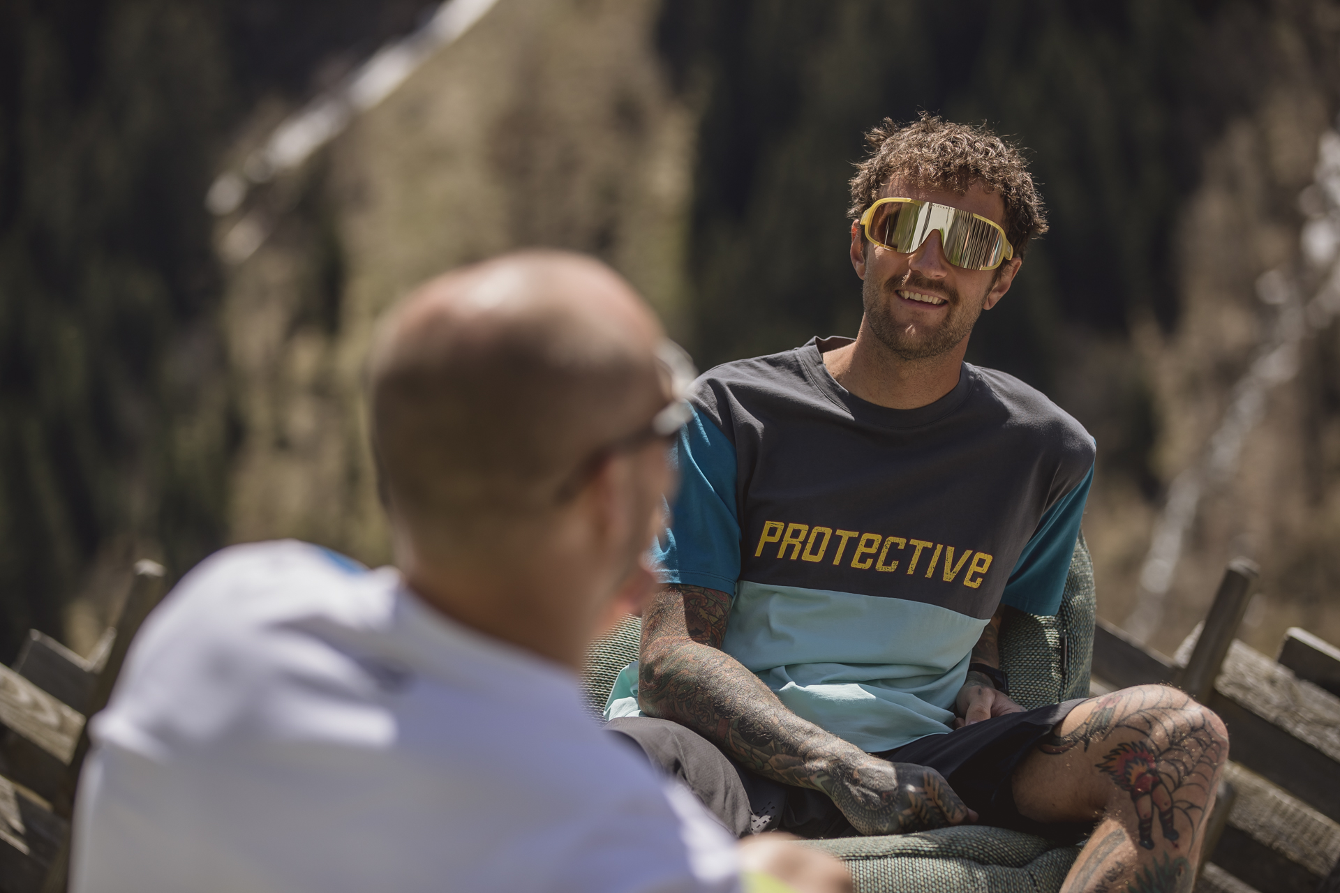 Lachender Mountainbiker im PROTECTIVE-Trikot bei einer Pause in Saalbach