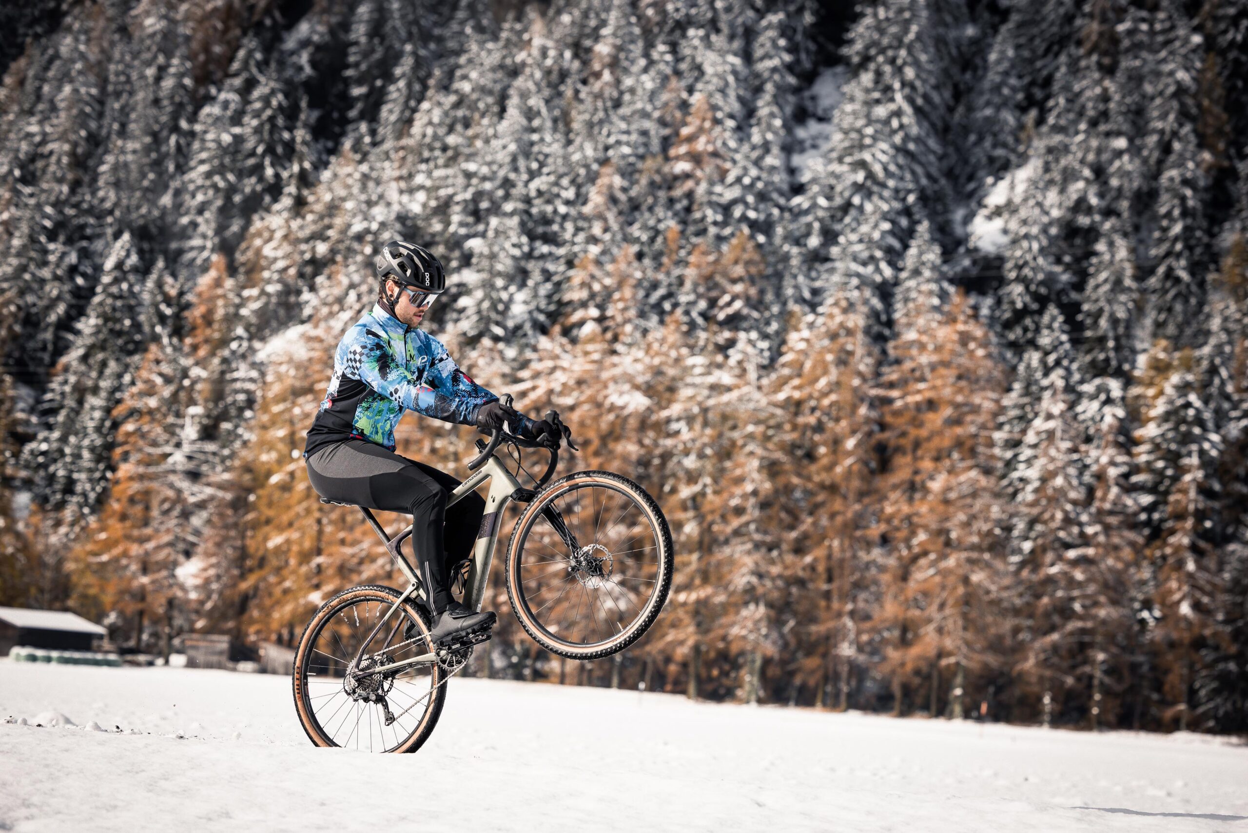 Mountainbiker im verschneiten Lärchenwald