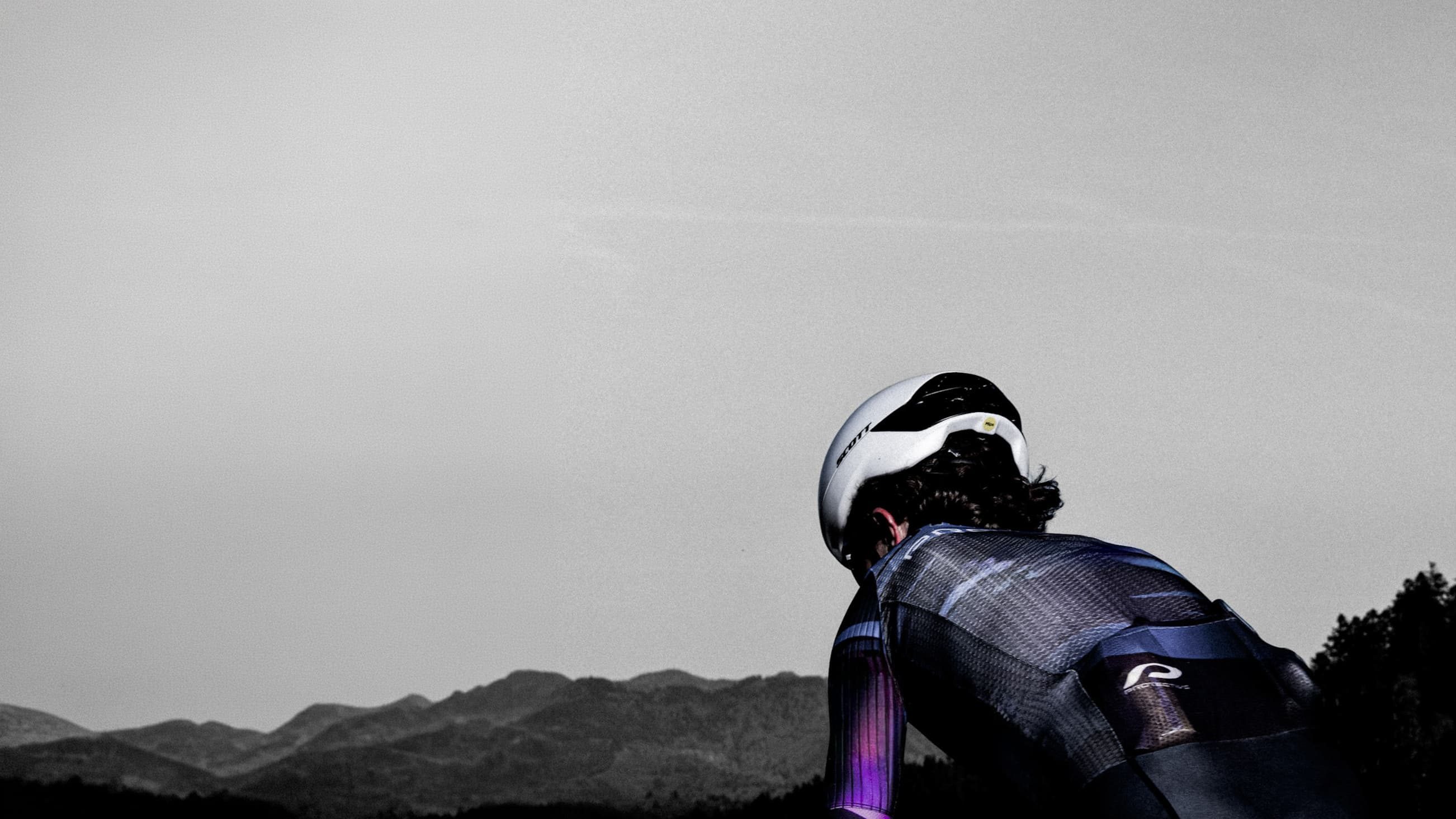 Radsportler mit Helm vor einem Bergpanorama